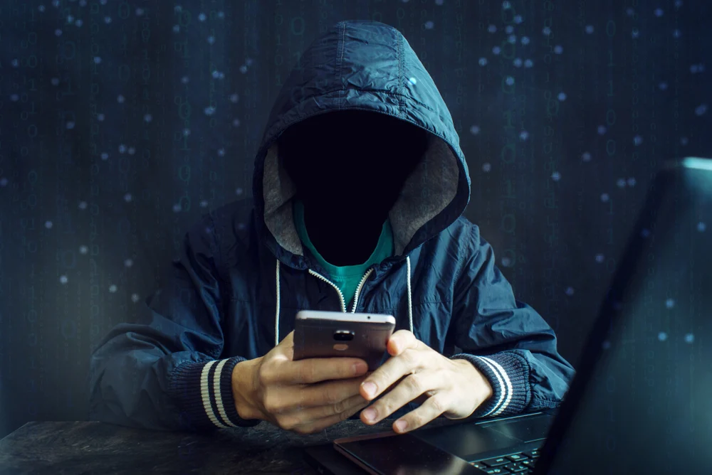 An,anonymous,hacker,without,a,face,uses,a,mobile,phone