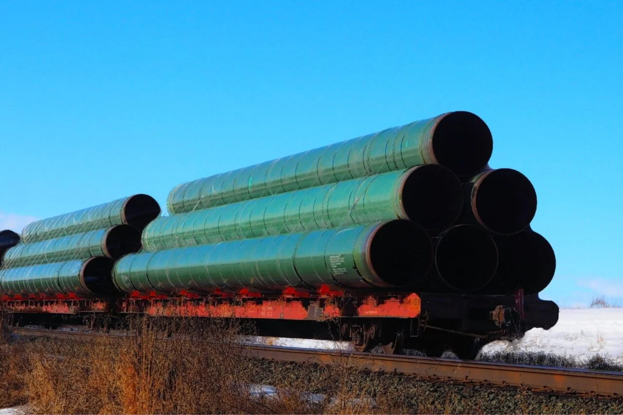 A railway flatcar loaded with large diameter pipe