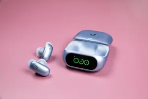 The blue Soundcore Liberty 5 Pro earbuds sitting next to their open case on a mauve background.