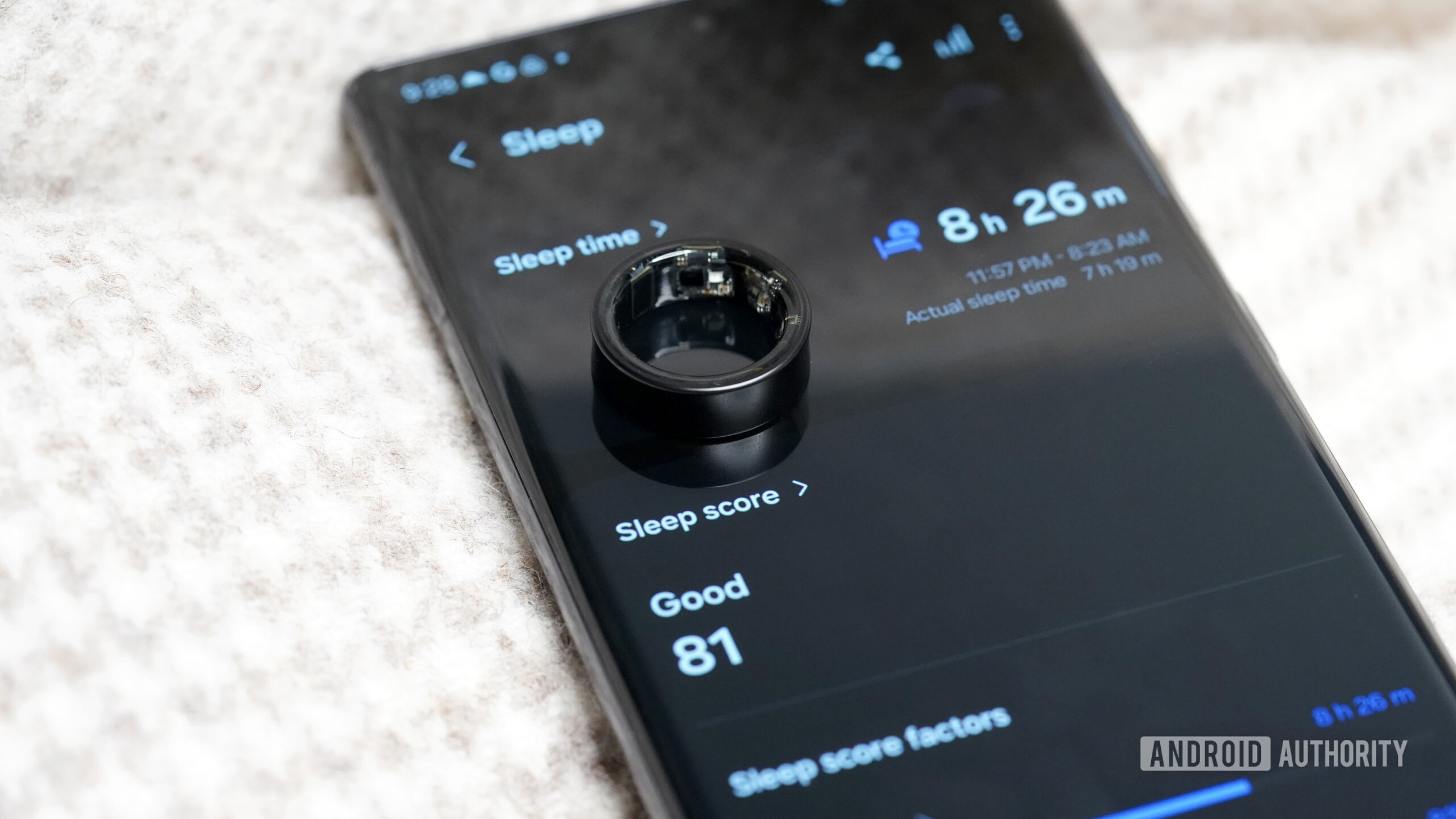 Samsung Galaxy Ring Sleep Score A Samsung Galaxy Ring rests on a user's sleep data displayed on their phone.