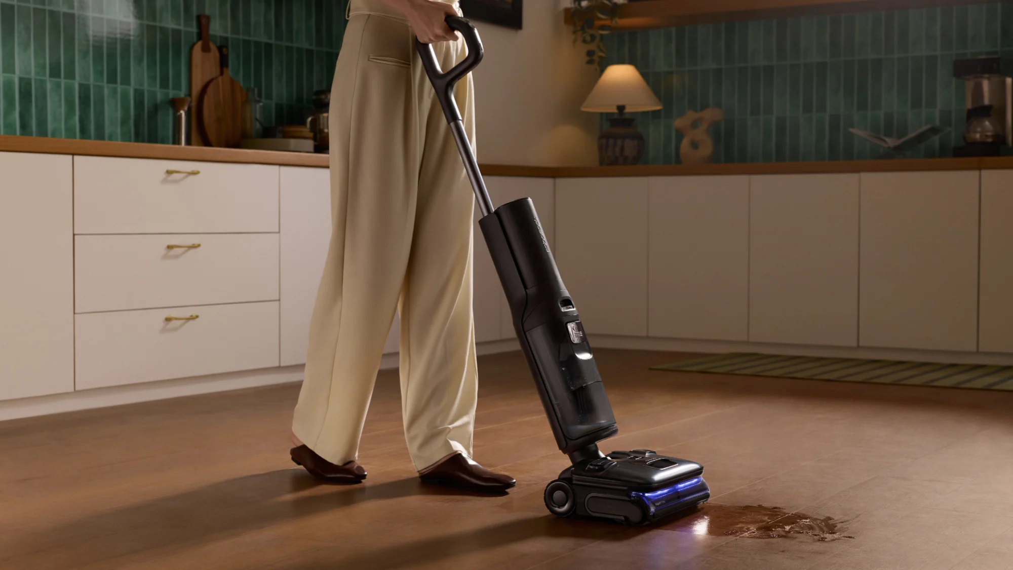 The Roborock F25 Ultra wet and dry vacuum cleaner cleaning up a wet spill in a kitchen.