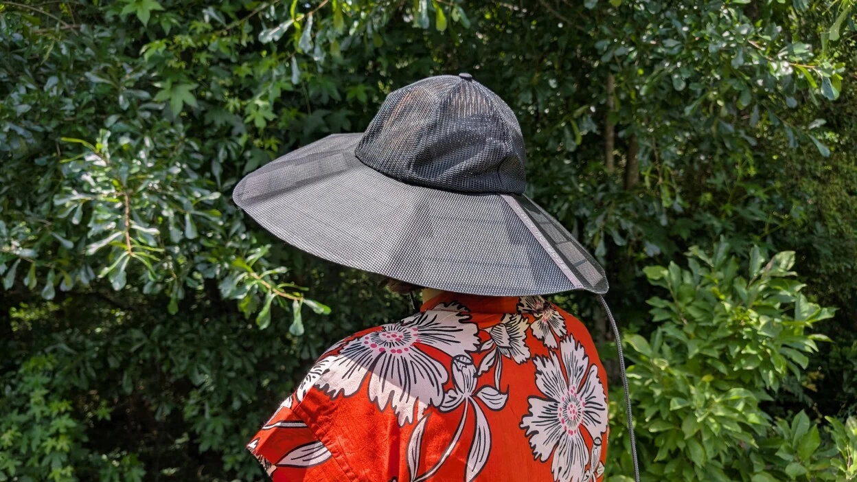 the ecoflow power hat on a person's head who is standing outside while wearing an orange dress