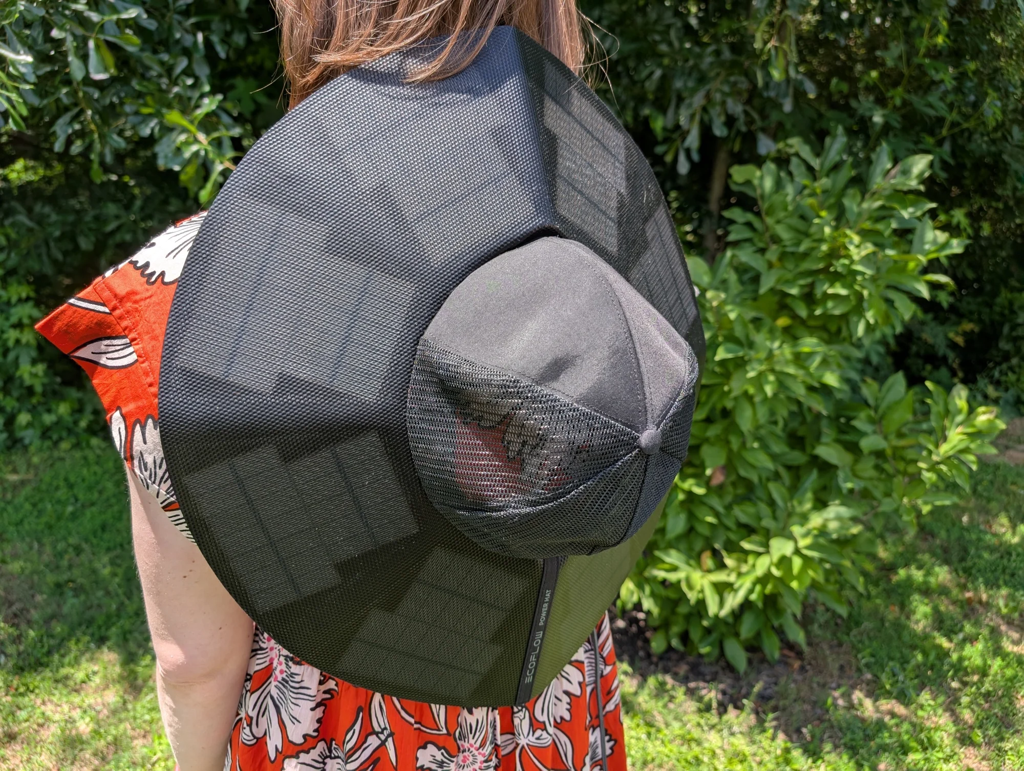 the ecoflow power hat worn on the back of a person who's standing outside