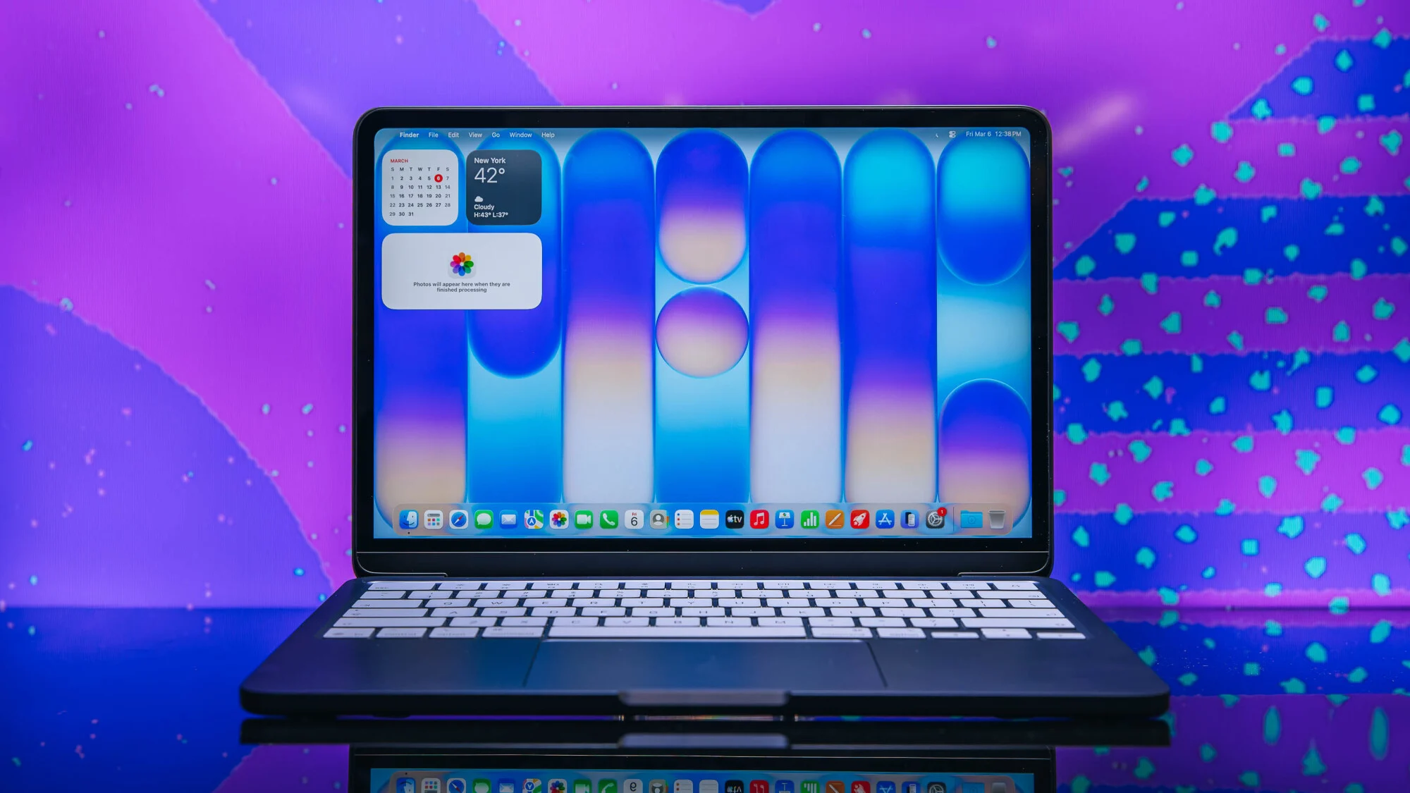 apple macbook neo in indigo posed in front of purple background