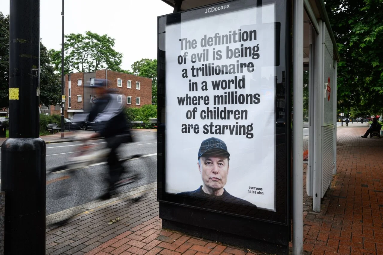 An unofficially-installed poster critical of Elon Musk's wealth is displayed on a bus shelter on June 11, 2026 in Tottenham, England.