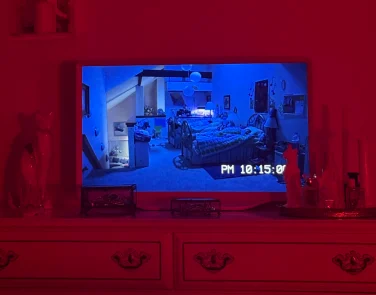 Hisense D&eacute;co TV sitting on dresser while playing a scene from "Paranormal Activity 3"