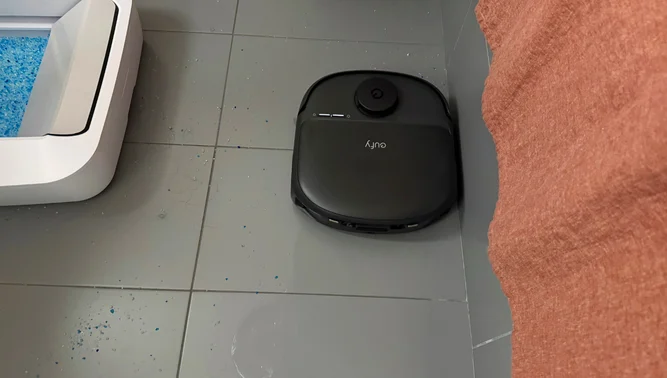 Eufy C28 robot vacuum mopping tile floor near shower wall and litter box