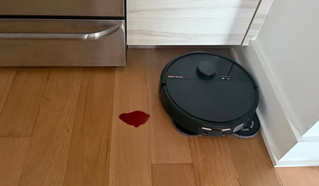 Roomba Plus 505 Combo mopping hardwood floor near wine spill and oven