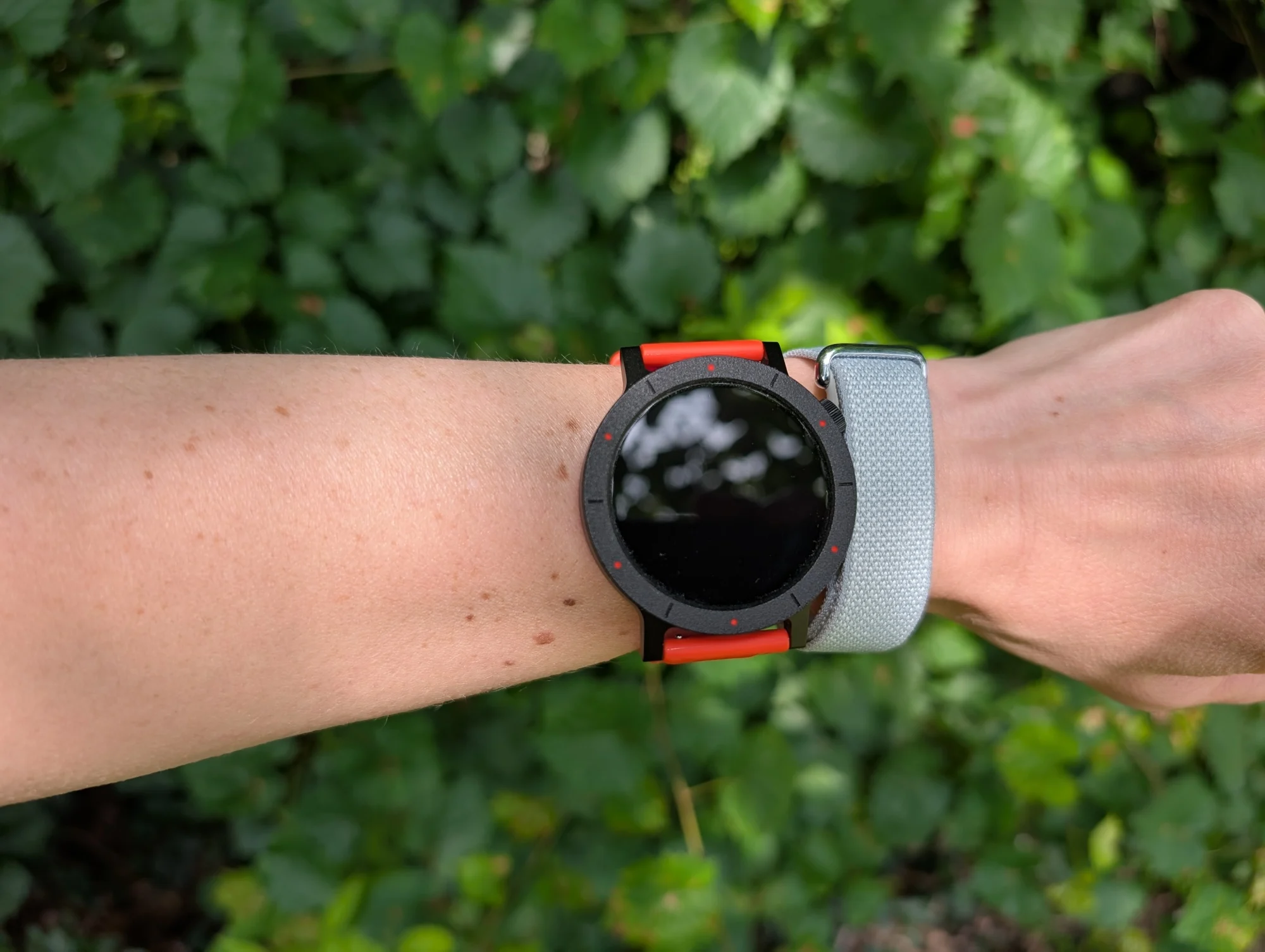 the google fitbit air on a wrist next to the cmf nothing watch 3 pro