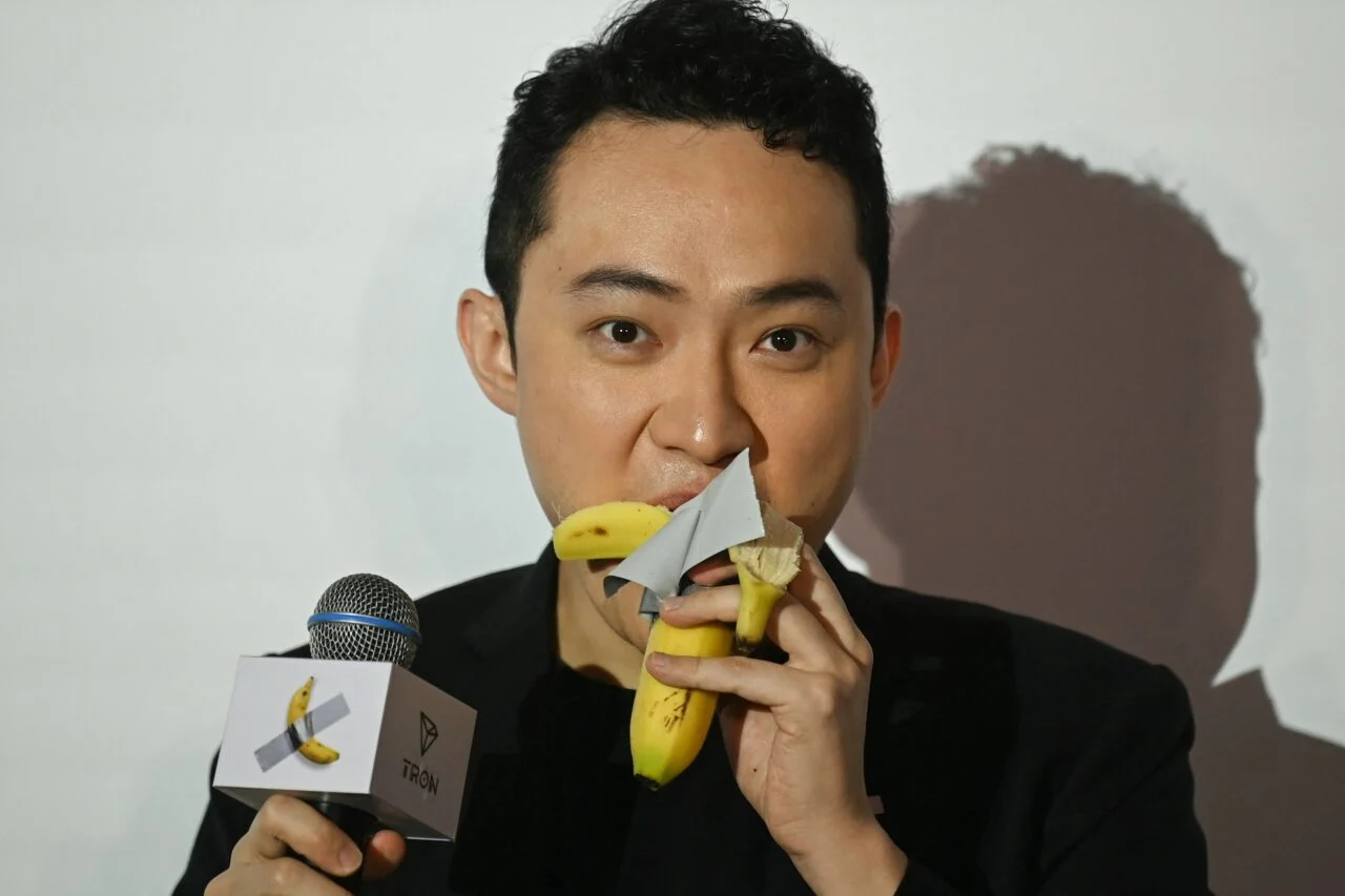 A photo of Justin Sun eating a banana at a press conference.