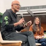 Satya Nadella sits with Asha Sharma in a meeting.