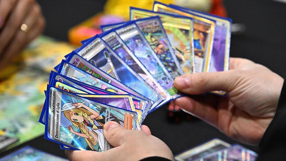 A competitor holds a deck showing a Determinazione Lylia card as they play the Pokémon Trading Card Game during the Pokemon Europe International Championships at ExCel London on February 13, 2026 in London, England.