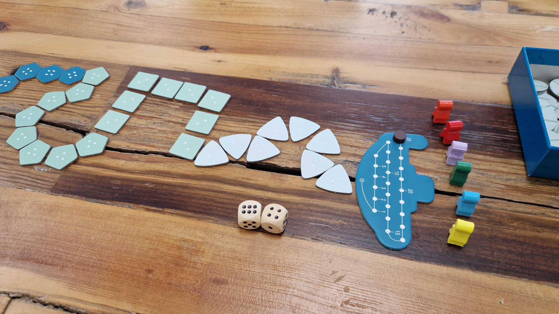 Deep Sea Adventure submarine, tokens, dice, and movers on a wooden table