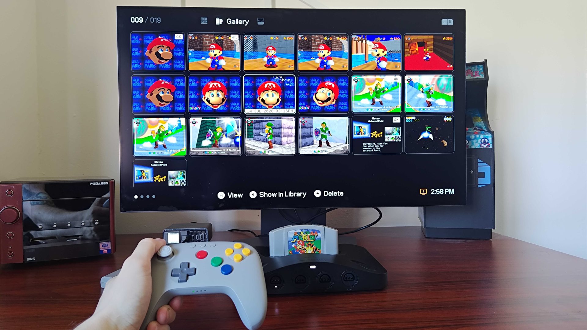 Analogue 3D plugged into monitor with screenshot Gallery open and hand holding controller.