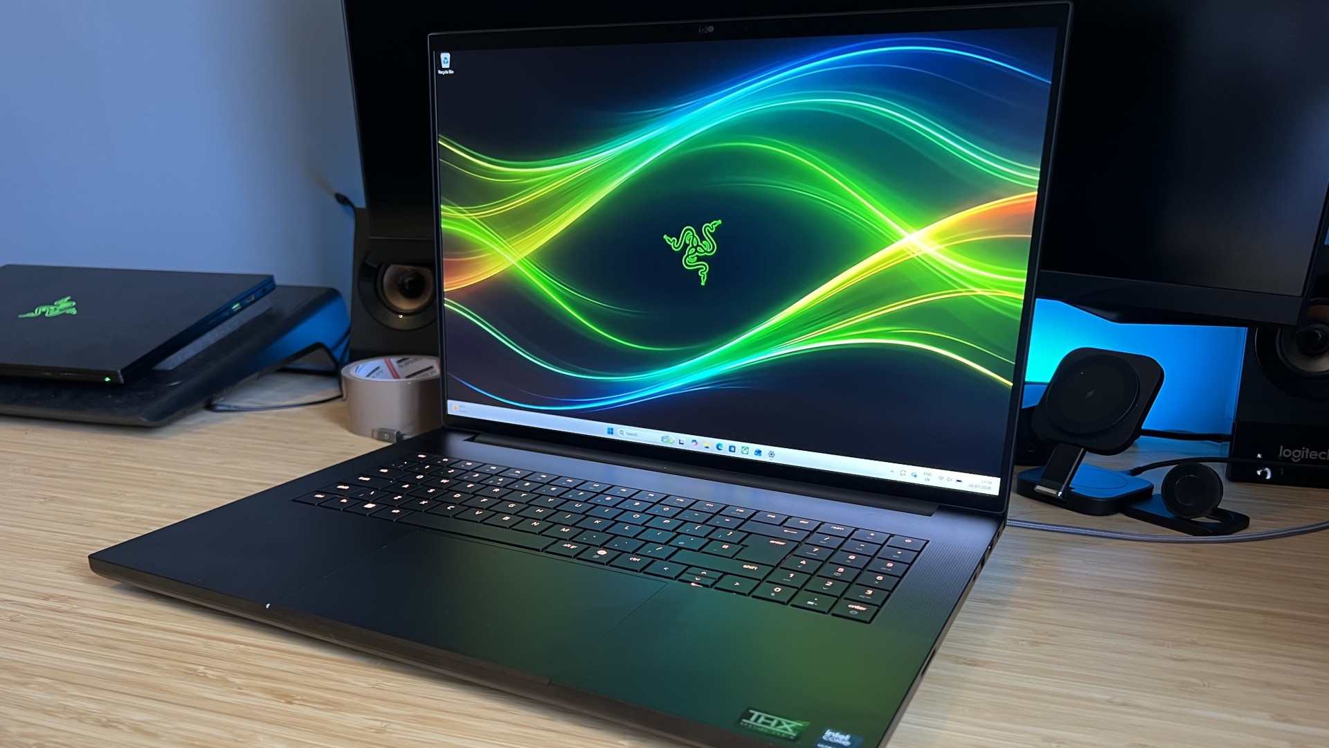 Razer Blade 18 gaming laptop sitting on a wooden desk with blue backlighting