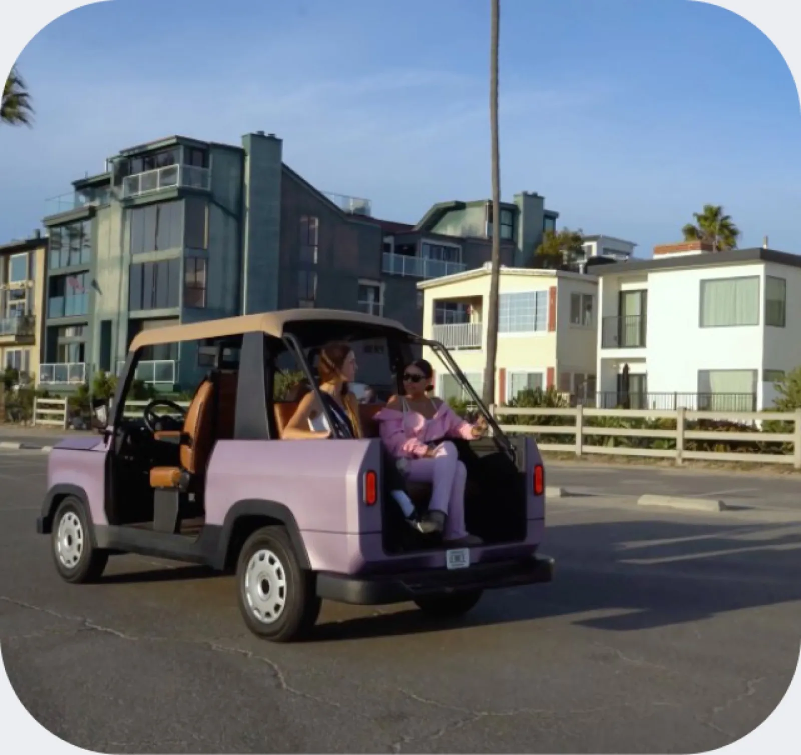 A purple Chip Motors LUV parked on a coastal street