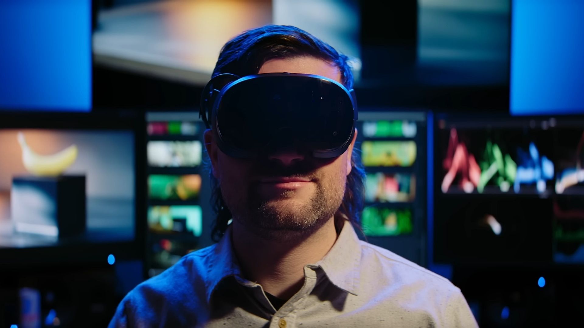 An image of a man wearing a Steam Frame headset in a darkened room
