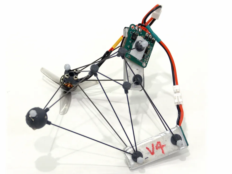 A minimalist drone made of a few thin rods, wires and a miniature circuit board.